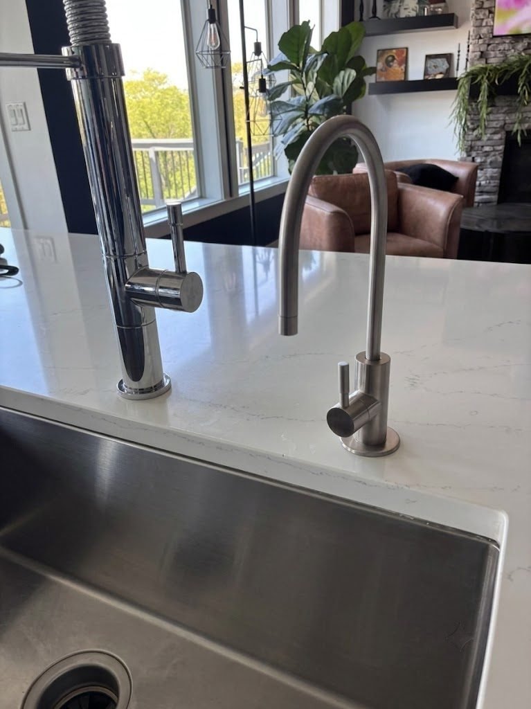 Chrome reverse osmosis drinking water faucet installed next to the main kitchen faucet